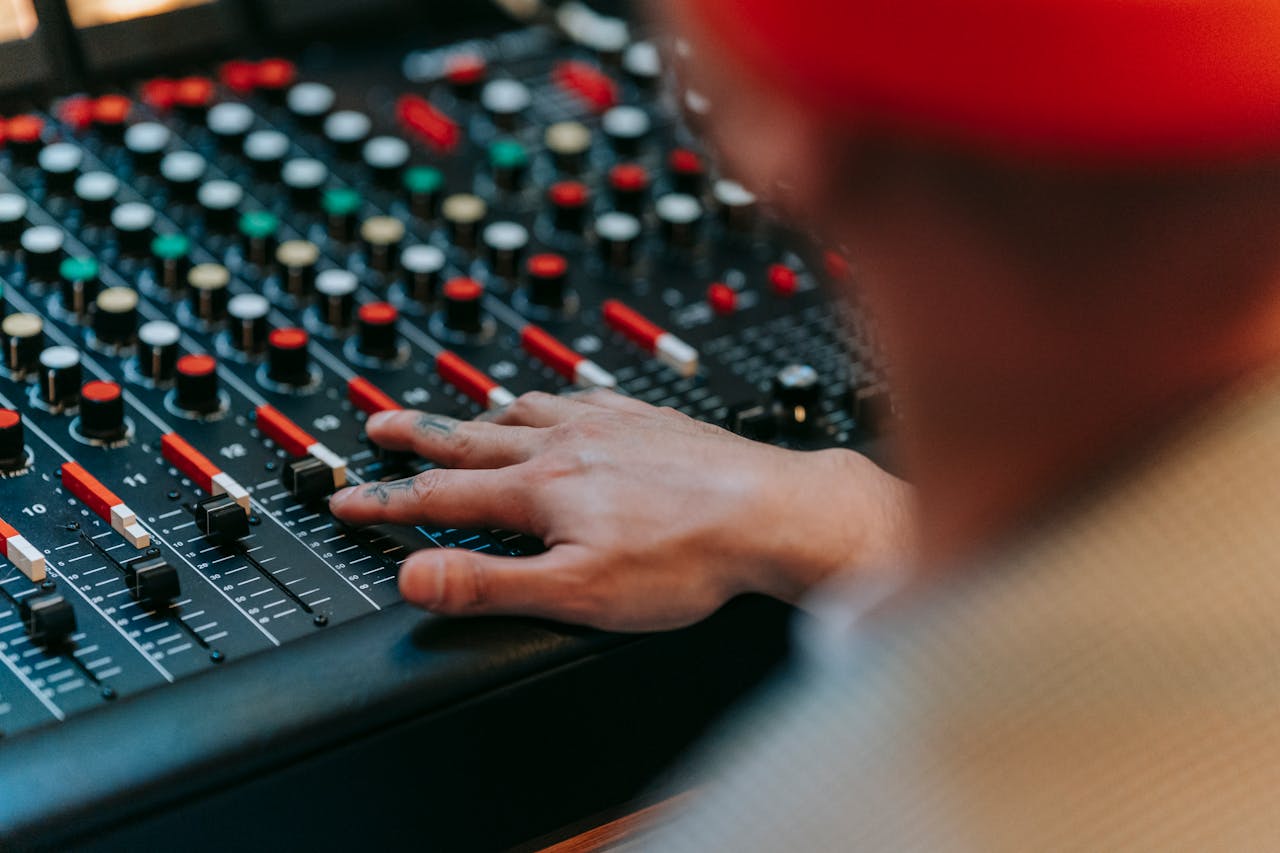 services-04 Sound engineer adjusting audio mixing console in studio setting, capturing the essence of music production.